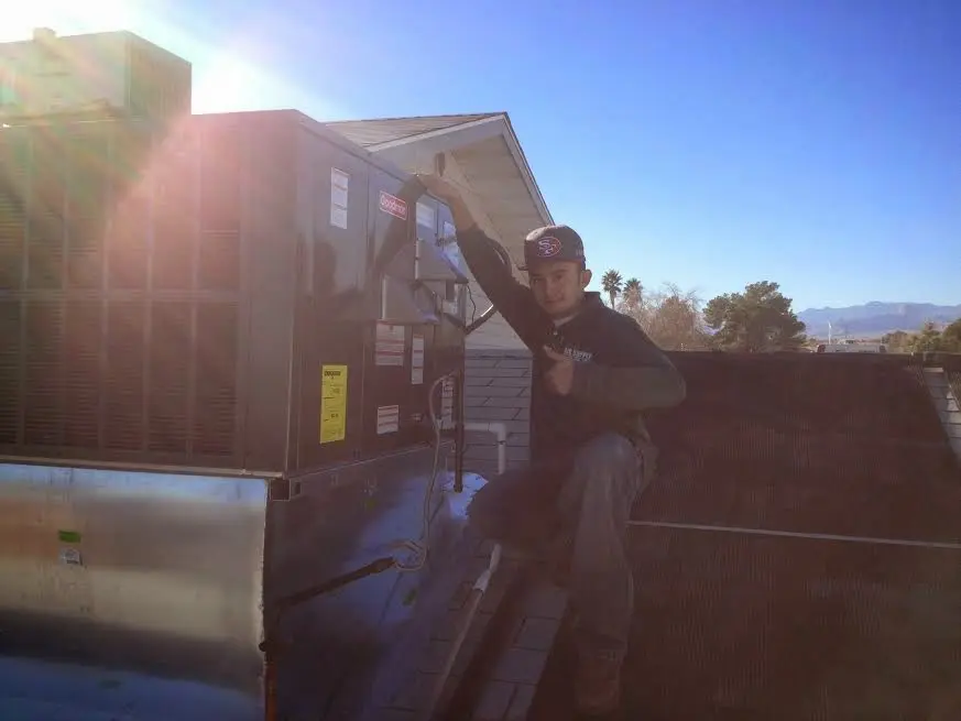 HVAC technician performing Heat Pump Repair on a rooftop unit in Five Forks